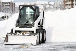 Image of a small snow plough in a parking lot